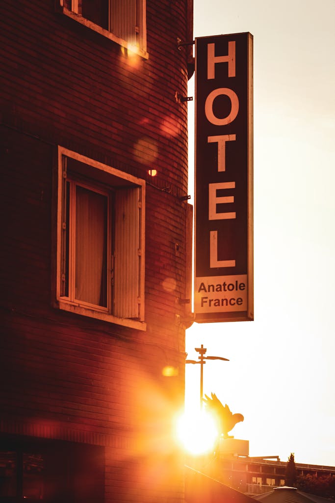 Sunset view of the Hotel Anatole France sign in Toulouse, capturing warm tones and urban architecture.